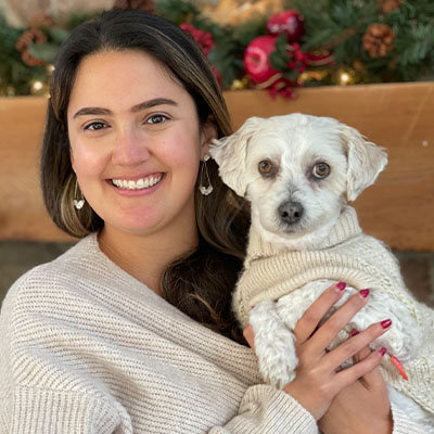 Headshot of Dr Martina Morris, veterinarian with her little white dog